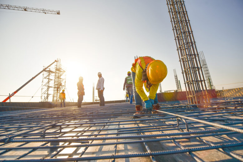 Construction workers fabricating steel reinforcement bar at the